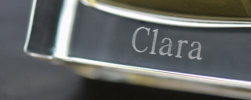 透明なガラス製香水瓶の底に「Clara」という名前の香水彫刻