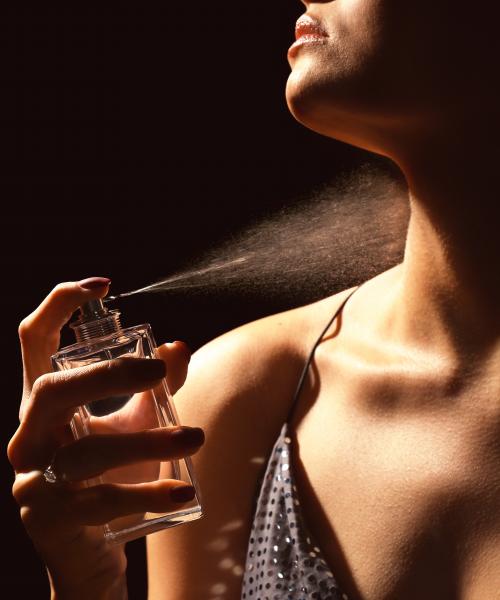 Woman spraying perfume