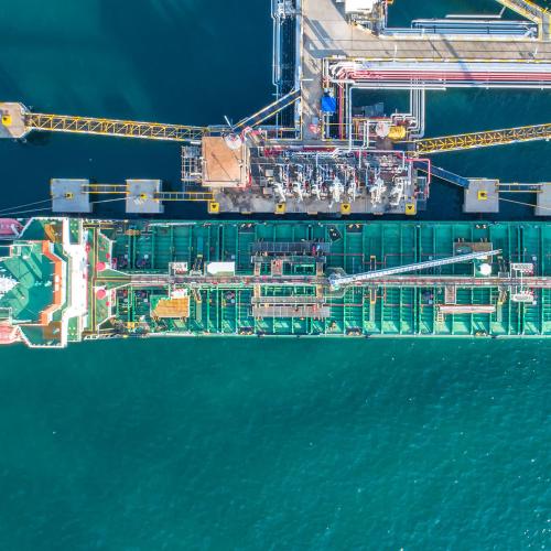 Top-down view of cargo ship being refueled and loaded